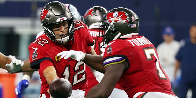 Tom Brady (12) hands off to Leonard Fournette (7) of the Tampa Bay Buccaneers during a game against the Dallas Cowboys at AT and T Stadium Sept. 11, 2022, in Arlington, Texas.