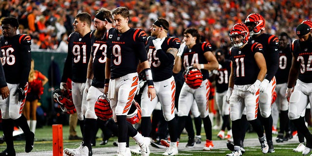 Joe Burrow #9 of the Cincinnati Bengals and teammates walk to the locker room after the game against the Buffalo Bills was suspended after Damar Hamlin of the Bills collapsed on the field, Jan. 2, 2023, in Cincinnati.