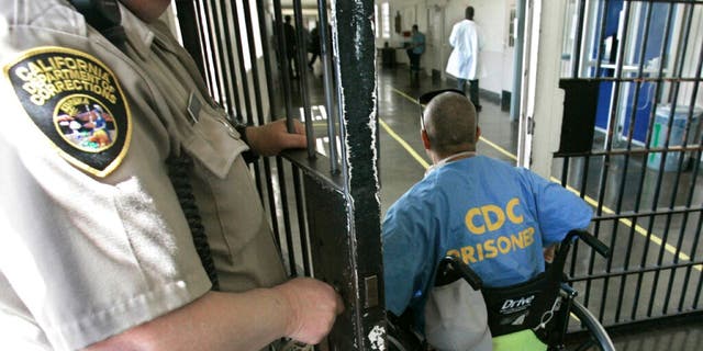 A wheelchair-bound inmate goes through a checkpoint at the California Medical Facility in Vacaville, Calif., on April 9, 2008. A prominent California medical school has apologized for conducting unethical experimental medical treatments on 2,600 incarcerated men in the 1960s and 1970s.