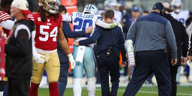 Tony Pollard of the Dallas Cowboys is assisted by medical staff after suffering an injury against the San Francisco 49ers at Levi's Stadium on January 22, 2023, in Santa Clara, California.