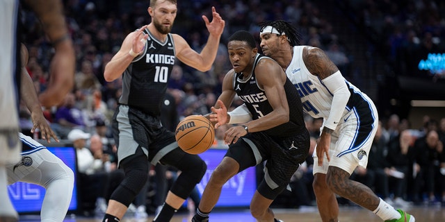 Orlando Magic guard Gary Harris, #14, knocks the ball away from Sacramento Kings guard De'Aaron Fox, #5, in the second half in an NBA basketball game in Sacramento, California, Monday, Jan. 9, 2023. 