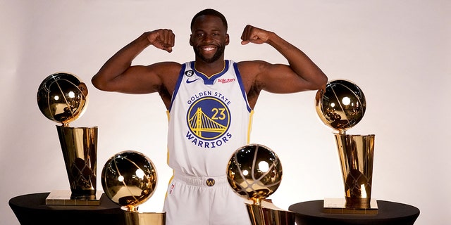 Golden State Warriors forward Draymond Green poses with the Larry O'Brien Championship Trophies during Media Day at the Chase Center in San Francisco on Sept. 25, 2022.