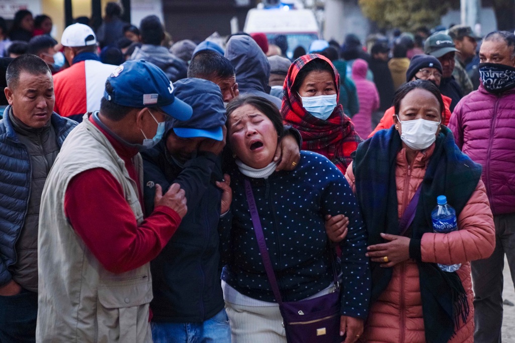 A woman cries as the body of a relative, a victim of a plane crash, is brought to a hospital in Pokhara, Nepal, Sunday, Jan. 15, 2023