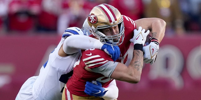 San Francisco 49ers tight end George Kittle is tackled by Dallas Cowboys linebacker Anthony Barr during the NFC divisional round playoff game at Levi's Stadium, Jan. 22, 2023, in Santa Clara, California.