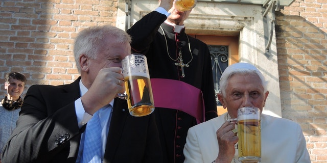 The retired Pope Benedict XVI (R) and the premier of the state of Bavaria, Horst Seehofer (CSU), drink a glass of beer in the Vatican Garden in Vatican City, 17 April 2017. Benedict's private secretary Georg Gaenswein stands behind the two. Benedict is celebrating his 90th birthday and received visitors from Bavaria, the German state from which he hails. His actual birthday was celebrated with a small circle of intimates including his older brother Georg, Gaenswein and his housekeeper.