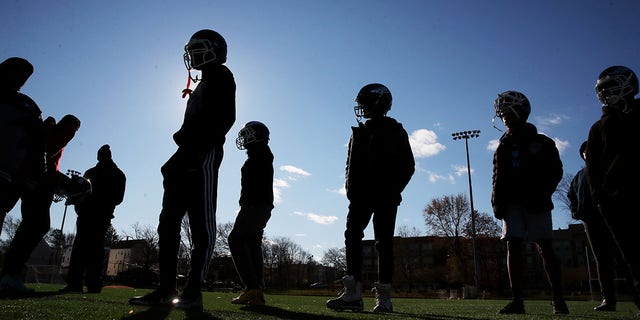 Players line up during the Dorchester Eagles Pop Warner football team practice in the Dorchester neighborhood of Boston, MA, on November 27, 2021. Coaches Tony Hurston and Terry Cousin have led the Eagles to a spot in the Pop Warner's annual Super Bowl Championships. 