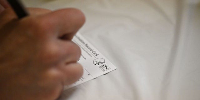 A nurse fills out a Centers for Disease Control (CDC) vaccine record card at an L.A. Care Health Plan vaccination clinic at Los Angeles Mission College in the Sylmar neighborhood in Los Angeles, California, January 19, 2022. 