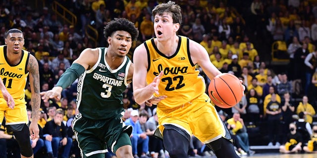 Iowa forward Patrick McCaffery, #22, drives to the basket around Michigan State Spartans guard Jaden Akins, #3, in the second half during a college basketball game between the Michigan State Spartans and the Iowa Hawkeyes on Feb. 22, 2022, at Carver-Hawkeye Arena, Iowa City, Iowa.