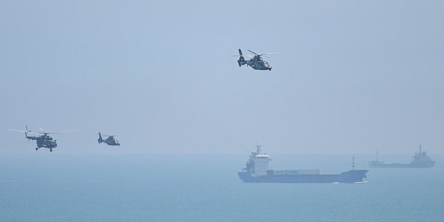 TOPSHOT - Chinese military helicopters fly past Pingtan island, one of mainland China's closest point from Taiwan, in Fujian province on August 4, 2022.