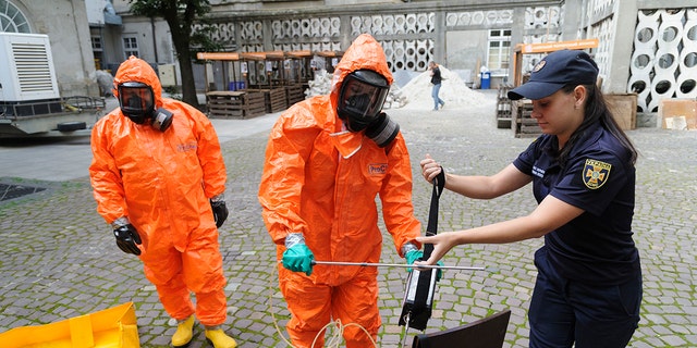 Ukrainian Emergency Ministry rescuers wear protective clothing during a nuclear emergency training session for civilians in Kyiv on Sept. 7, 2022.