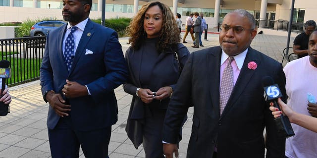 Defense lawyer A. Scott Bolden, right, proclaims his client Marilyn Mosby, middle, is innocent after leaving federal court with her and her husband, Nick Mosby, on Tuesday, Sept. 14, 2022, in Baltimore. 