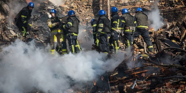 Ukrainian rescuers work at the site of a residential building destroyed by a Russian drone strike, which local authorities consider to be Iranian-made unmanned aerial vehicles Shahed-136, in central Kyiv, Ukraine, Oct. 17, 2022.