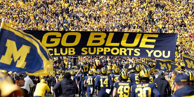 Michigan Wolverines players run onto the field before a game against the Penn State Nittany Lions Oct. 15, 2022, at Michigan Stadium in Ann Arbor, Mich. 