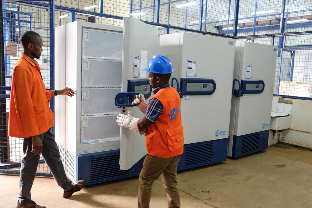 An employee closes an ultra-low temperature freezer containing Ebola trial vaccines at National Medical Stores in Entebbe, Uganda.