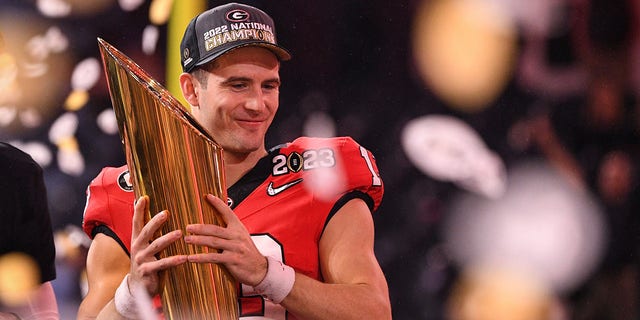 Georgia Bulldogs quarterback Stetson Bennett (13) holds the championship trophy after the Georgia Bulldogs defeated the TCU Horned Frogs in the College Football Playoff national championship game Jan. 9, 2023, at SoFi Stadium in Inglewood, Calif. 