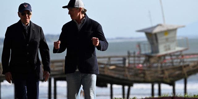 US President Joe Biden and California Governor Gavin Newsom walk to deliver remarks after looking at storm damage, and speaking to those affected in Seacliff, California, on January 19, 2023.