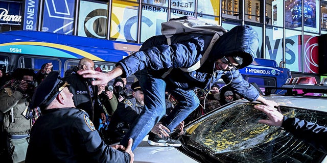 Police officers take a demonstrator, who smashed the window of a police car, into custody at Times Square in New York on Jan. 27, 2023.