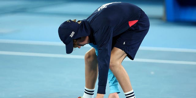 A ball kid moves a moth in the quarterfinal singles match between Greece's Stefanos Tsitsipas and Czech Republic's Jiri Lehecka during day nine of the 2023 Australian Open at Melbourne Park on Jan. 24, 2023 in Melbourne, Australia.  