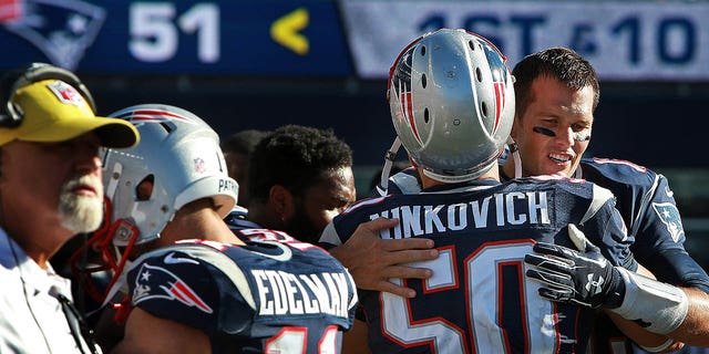 New England Patriots quarterback Tom Brady hugs linebacker Rob Ninkovich as the final seconds tick off the clock in an NFL game against the Jacksonville Jaguars at Gillette Stadium in Foxboro, Massachusetts, on Sept. 27, 2015.