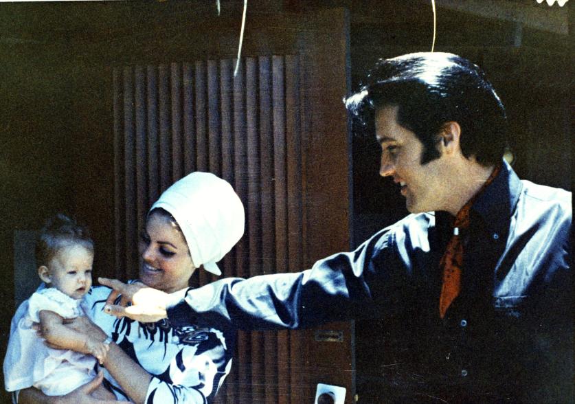 Lisa Marie Presley is held by mother Priscilla Presley, as Elvis Presley is also spotted in the photo.