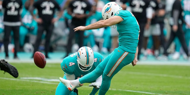 Miami Dolphins kicker Jason Sanders kicks a field goal as punter Thomas Morstead holds during the first half of an NFL football game against the New York Jets, Sunday, Jan. 8, 2023, in Miami Gardens, Florida.