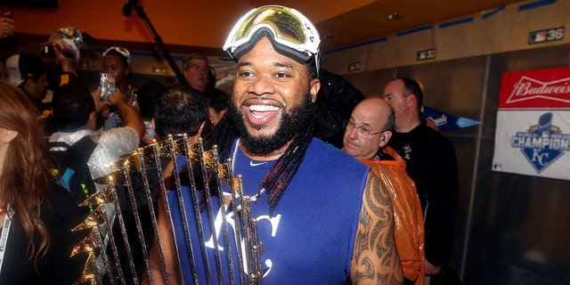 Johnny Cueto, #47 of the Kansas City Royals, celebrates with the Commissioner's trophy in the locker room after winning Game 5 of the 2015 World Series 7-2 over the New York Mets at Citi Field on Sunday, Nov. 1, 2015 in the Queens borough of New York City.