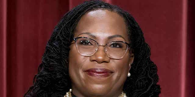 Associate Justice Ketanji Brown Jackson stands as she and members of the Supreme Court pose for a new group portrait following her addition, at the Supreme Court building in Washington, Oct. 7, 2022.