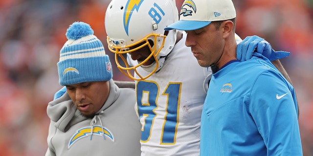 Trainers assist Mike Williams of the Los Angeles Chargers off the field during the first half of a game against the Denver Broncos at Empower Field At Mile High in Denver on Sunday.