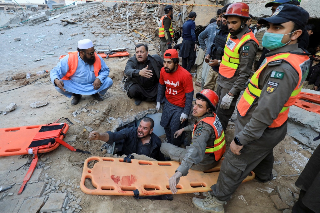 Rescue workers look for survivors under a collapsed roof, after a suicide blast in a mosque in Peshawar, Pakistan January 30, 2023.