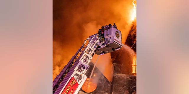 Portland firefighters use crane to pour water onto the Old Portland Korean Church. 