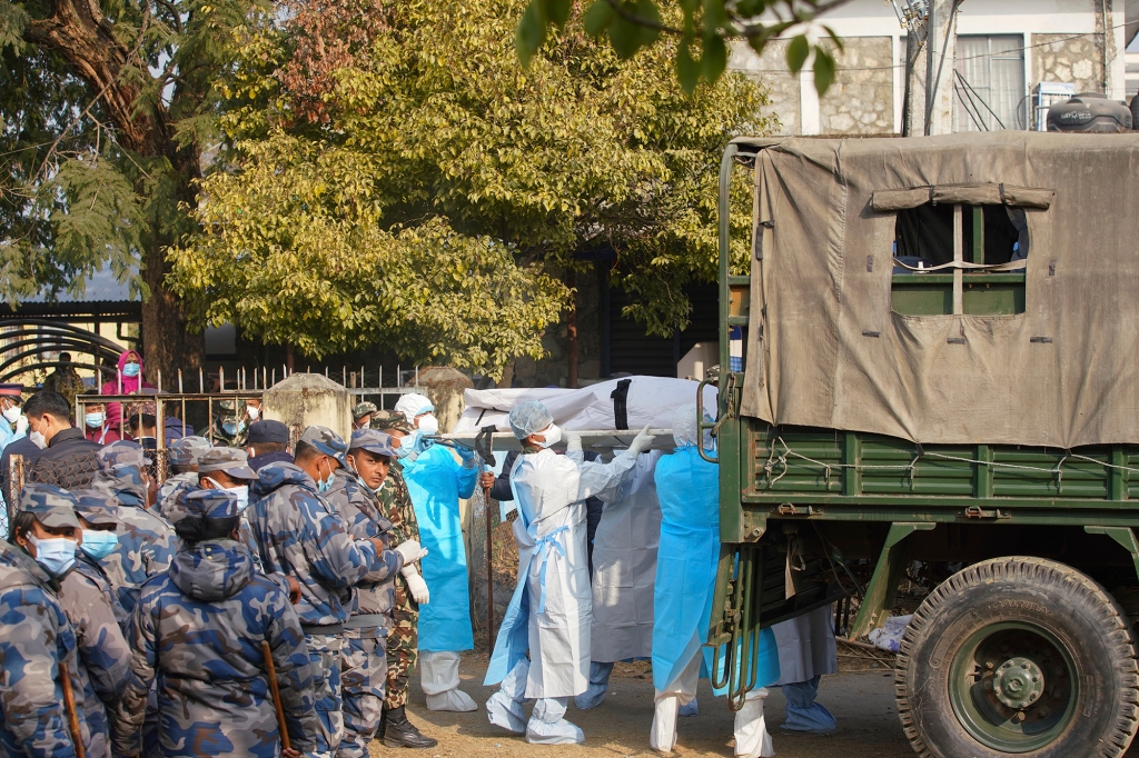 Medical personnel load the body of a victim onto a truck to be transported to Kathmandu, in Pokhara, Nepal, Tuesday, Jan 17, 2023. 