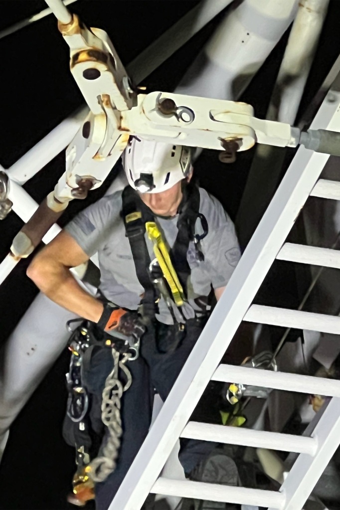 A rescue climber works on rescuing riders on the broken-down ride.