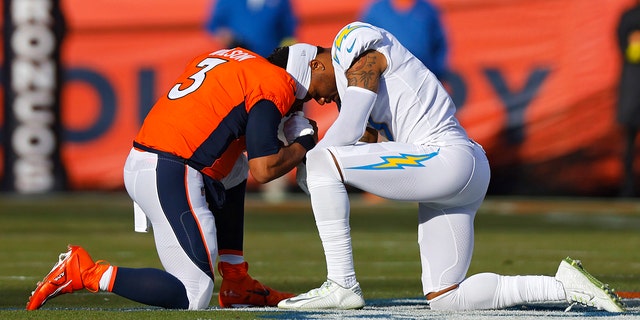 Russell Wilson #3 of the Denver Broncos and Derwin James Jr. #3 of the Los Angeles Chargers pray prior to their game at Empower Field At Mile High on January 08, 2023 in Denver, Colorado.