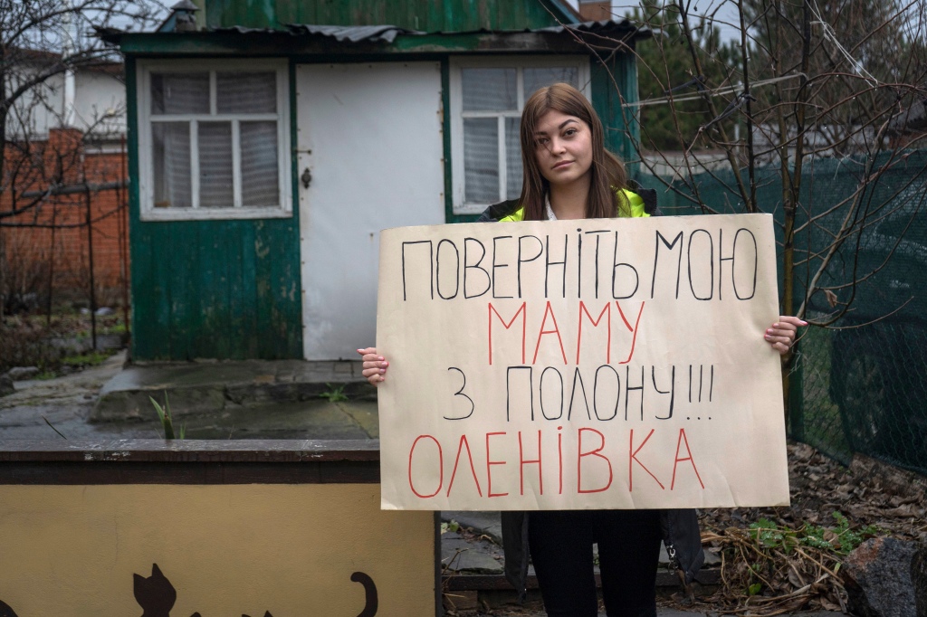 Alina Kapatsyna holds a poster that reads: "Bring back my mom from captivity," written in Ukrainian, in Dnipro, Ukraine, on Jan. 6, 2023. 