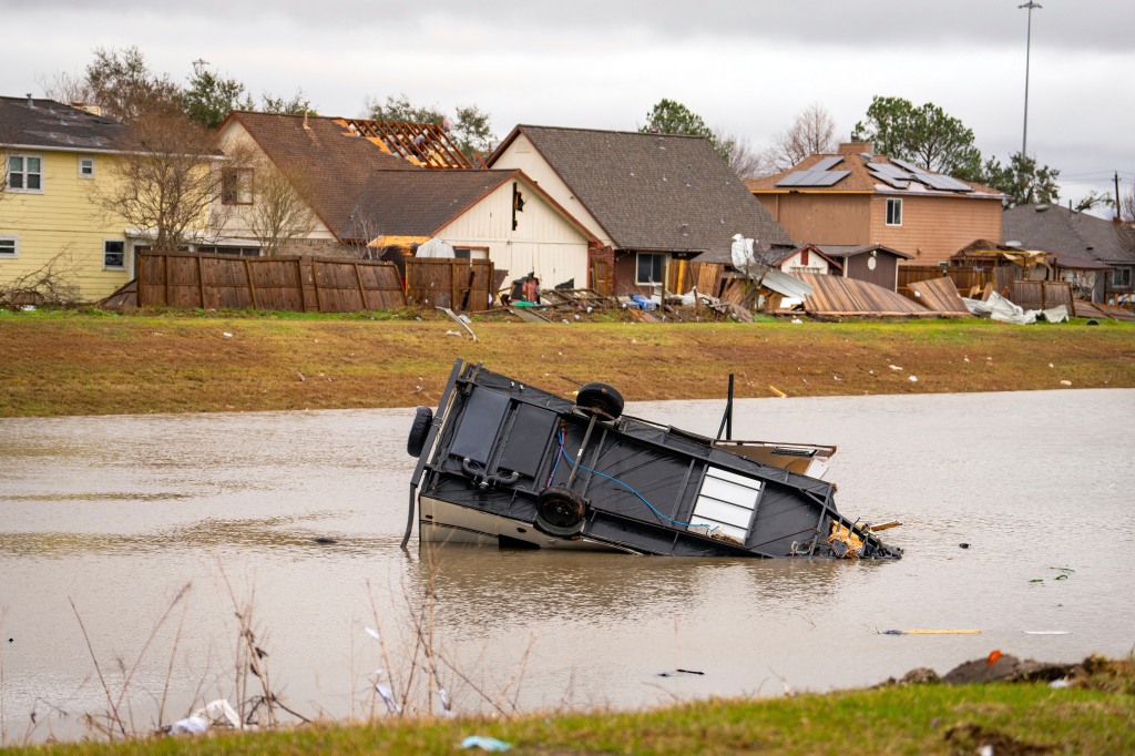 A camping trailer sits in a retention pond where a tornado was reported to pass along Mickey Gilley Blvd., near Fairmont Parkway, on Jan. 24, 2023, in Pasadena, Texas. 