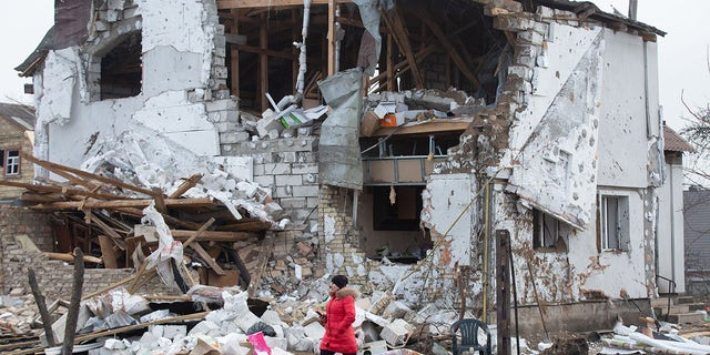 A woman walks near a residential building destroyed by a Russian missile attack in the town of Glevakha, Kyiv region, Ukraine on January 27, 2023. 