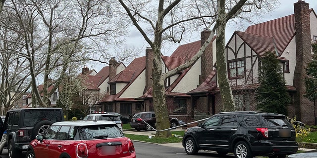 Police cordoned off the yard with tape as mourners left flowers at the base of a towering tree out front.