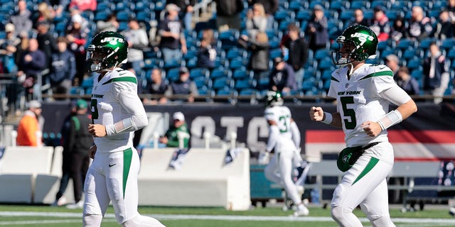 New York Jets quarterbacks Zach Wilson (2) and Mike White (5) run onto the field to warm up before a game against the New England Patriots Oct. 24, 2021, at Gillette Stadium in Foxborough, Mass. 