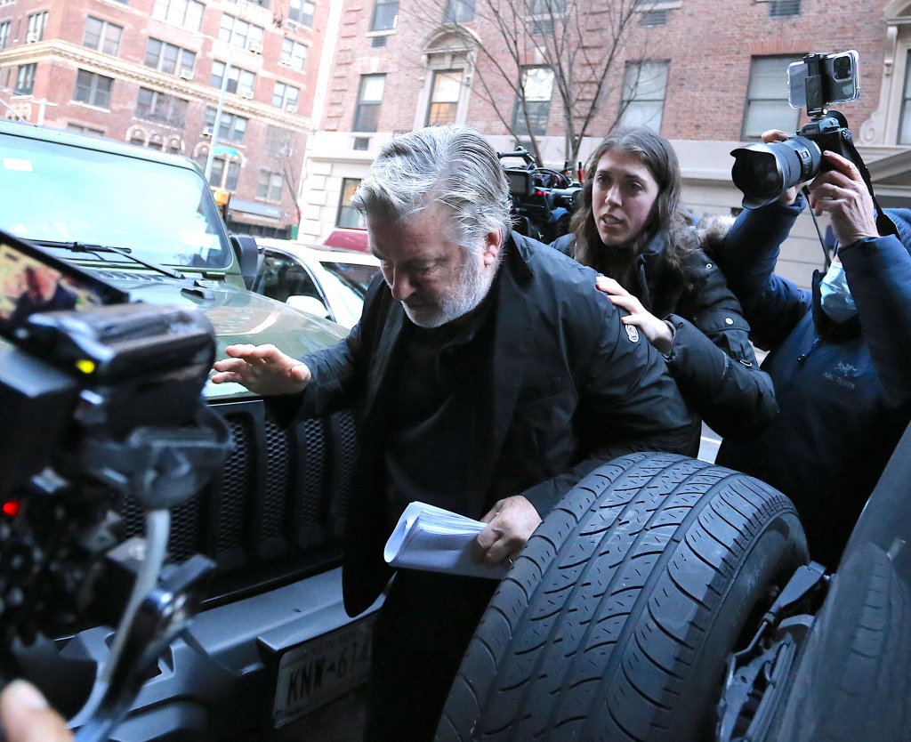 Alec Baldwin leaves a building with media waiting for him.