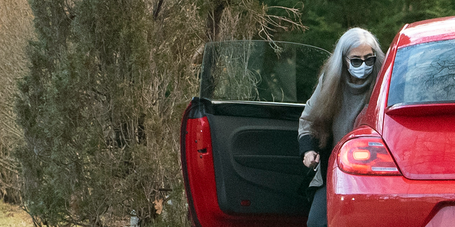 A woman who appears to be Diana Walshe is shown outside a red VW Bug.