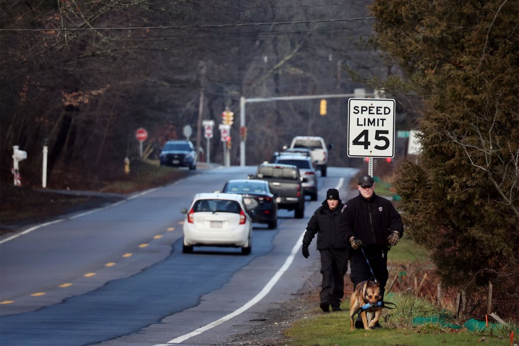 Members of a State Police K-9 unit search on Chief Justice Cushing Highway in Cohasset, Mass., Jan. 7, 2022.