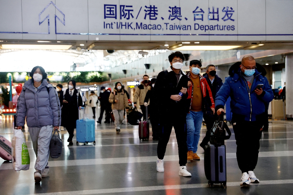 Travelers walk with their luggage at Beijing Capital International Airport.