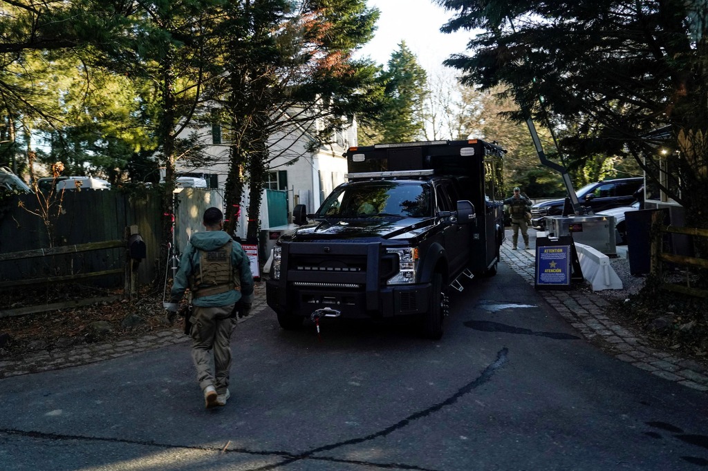 Secret Service personnel park vehicles in the driveway leading to U.S. President Joe Biden's house after classified documents were reported found there.