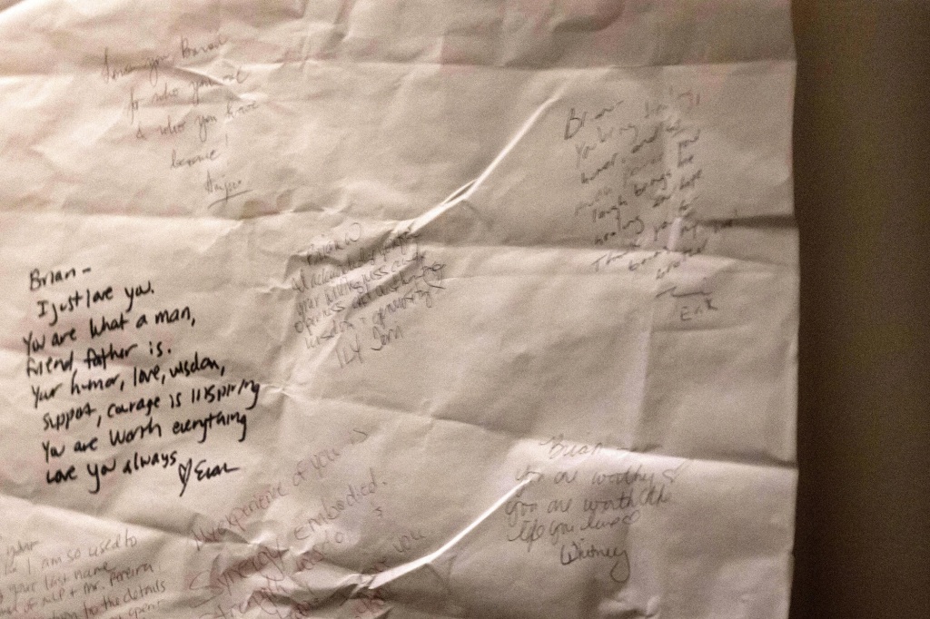 An unfolded poster is attached to a wall in the home of Brian and Ana Walshe that has a large number of people who signed it for Brian and offered praise and affirmations. 