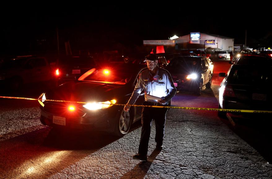 A San Mateo County sheriff deputy walks towards police tape as law enforcement officials conduct an investigation following a mass shooting on Jan. 23, 2023 in Half Moon Bay, California.