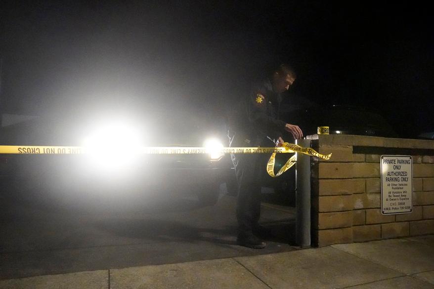 A law enforcement officer tapes off an entrance outside of a family reunification center after a shooting on Jan. 23, 2023, in Half Moon Bay, California.