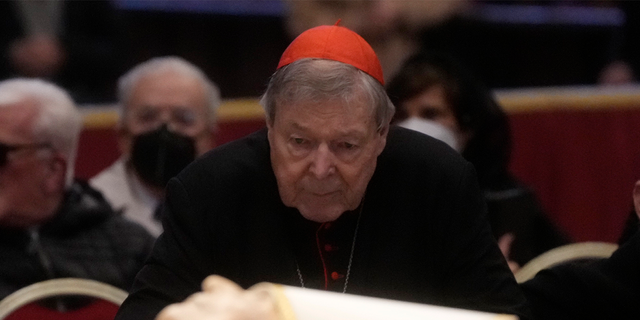 Australian Cardinal George Pell stands next to the body of late Pope Benedict XVI lying in state inside St. Peter's Basilica at The Vatican, Tuesday, Jan. 3, 2023.