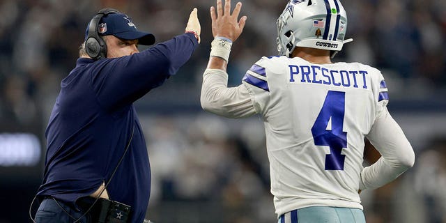 Head coach Mike McCarthy of the Dallas Cowboys celebrates with quarterback Dak Prescott, #4, after the Cowboys scored a touchdown against the Houston Texans in the fourth quarter at AT&amp;T Stadium on December 11, 2022, in Arlington, Texas.