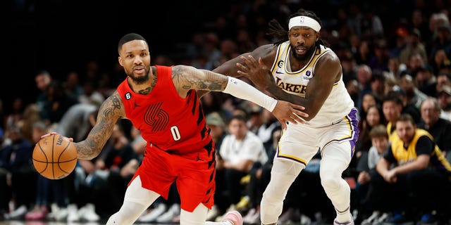 Damian Lillard #0 of the Portland Trail Blazers dribbles against Patrick Beverley #21 of the Los Angeles Lakers during the fourth quarter at Moda Center on January 22, 2023 in Portland, Oregon.