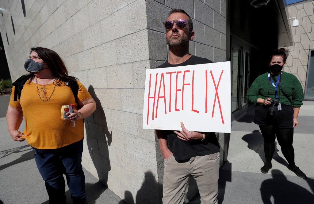 Man holds placard saying "Hateflix" at L.A. protest over Chappelle's Netflix show, "The Closer."